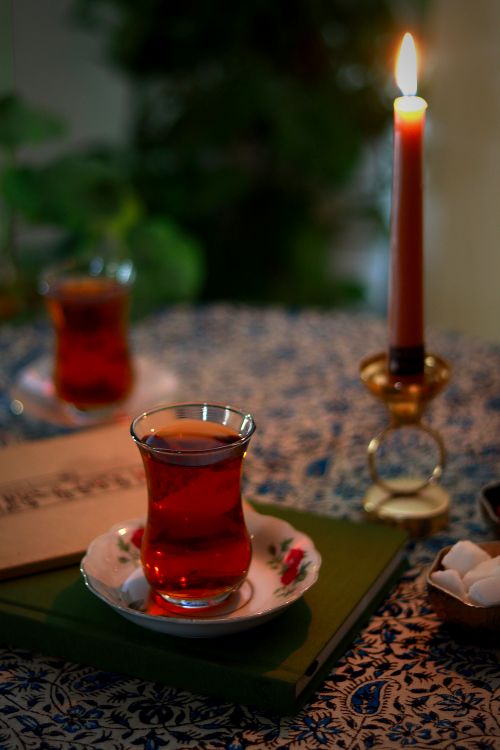 Free A warm, inviting tea setup at night with a candlelit ambiance and sugar bowl. Stock Photo