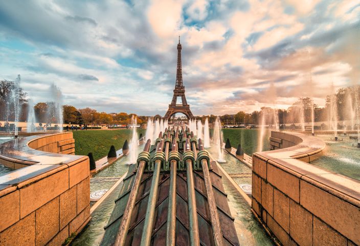 The Eiffel Tower stands majestically amidst the fountain display during a beautiful sunset in Paris.