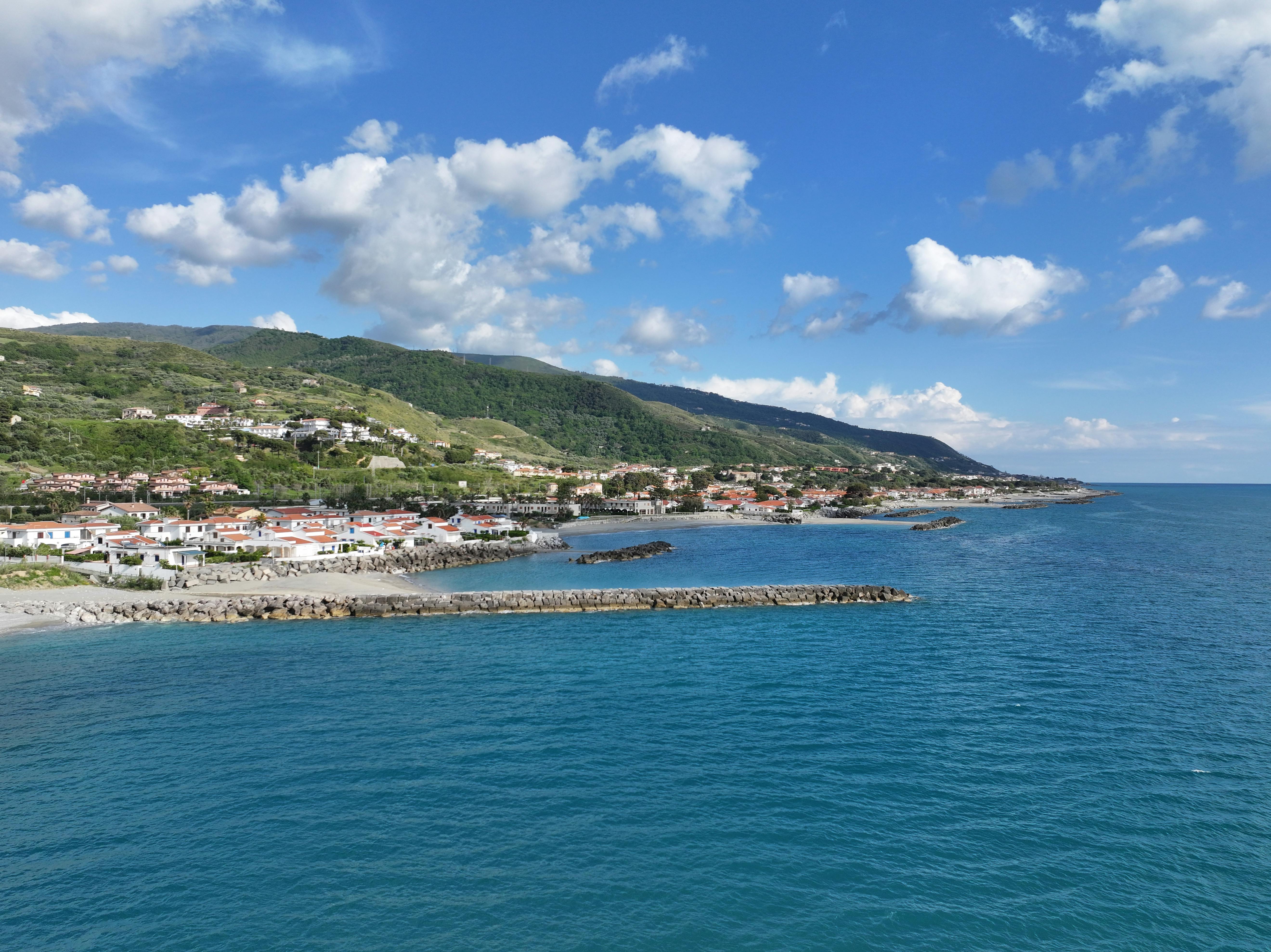 Turkuaz rengi denizin kıyısında yer alan, tarihi evleri ve eşsiz manzarasıyla büyüleyici bir sahil kasabası görünümü.