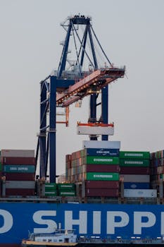 A large cargo container terminal with cranes at the Port of Rotterdam during twilight.