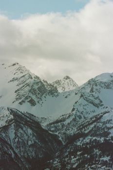 Breathtaking view of the Alps with snow-covered peaks and a cloudy sky, perfect for winter adventures.
