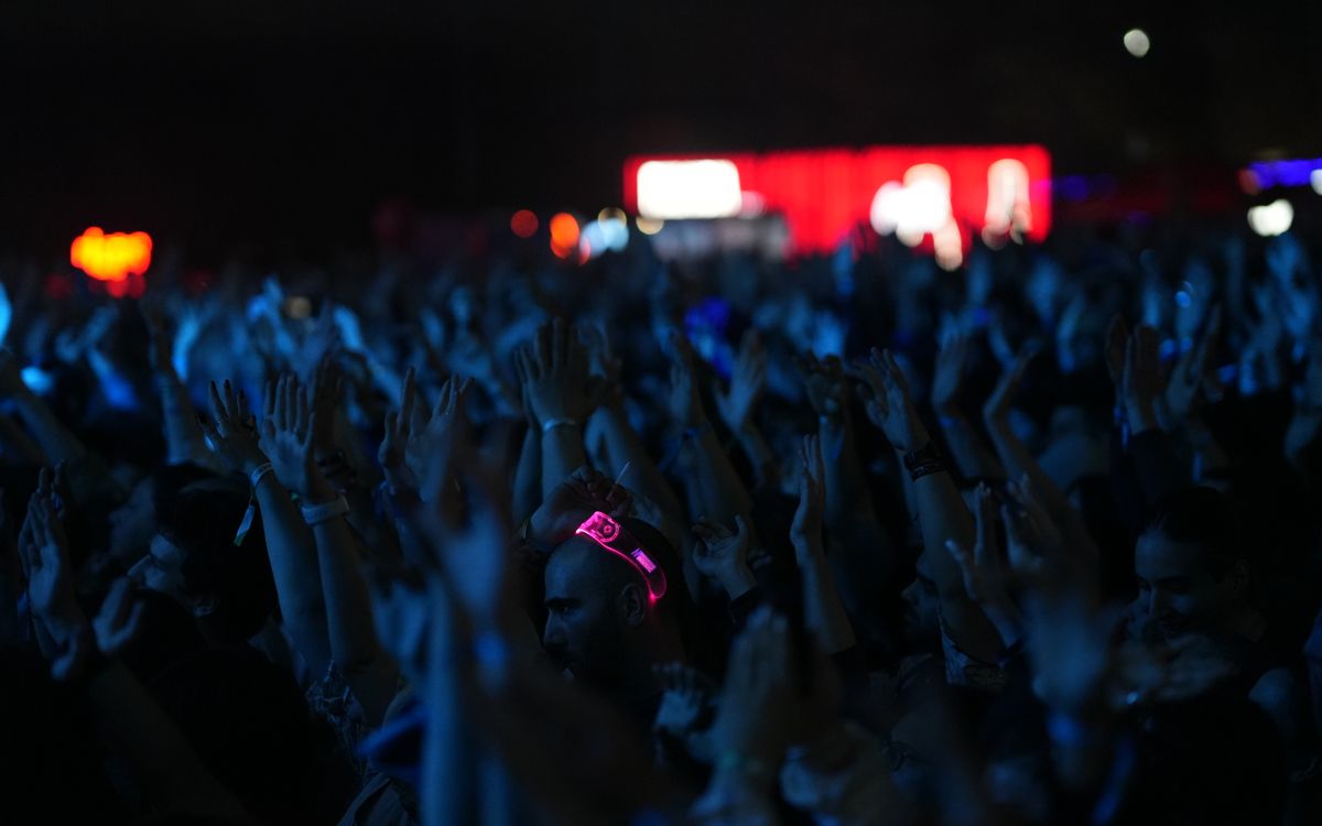 A lively concert scene with a crowd of people enjoying the music at night.