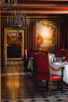 Luxurious dining room in a French restaurant with red chairs and chandeliers in Vonnas.