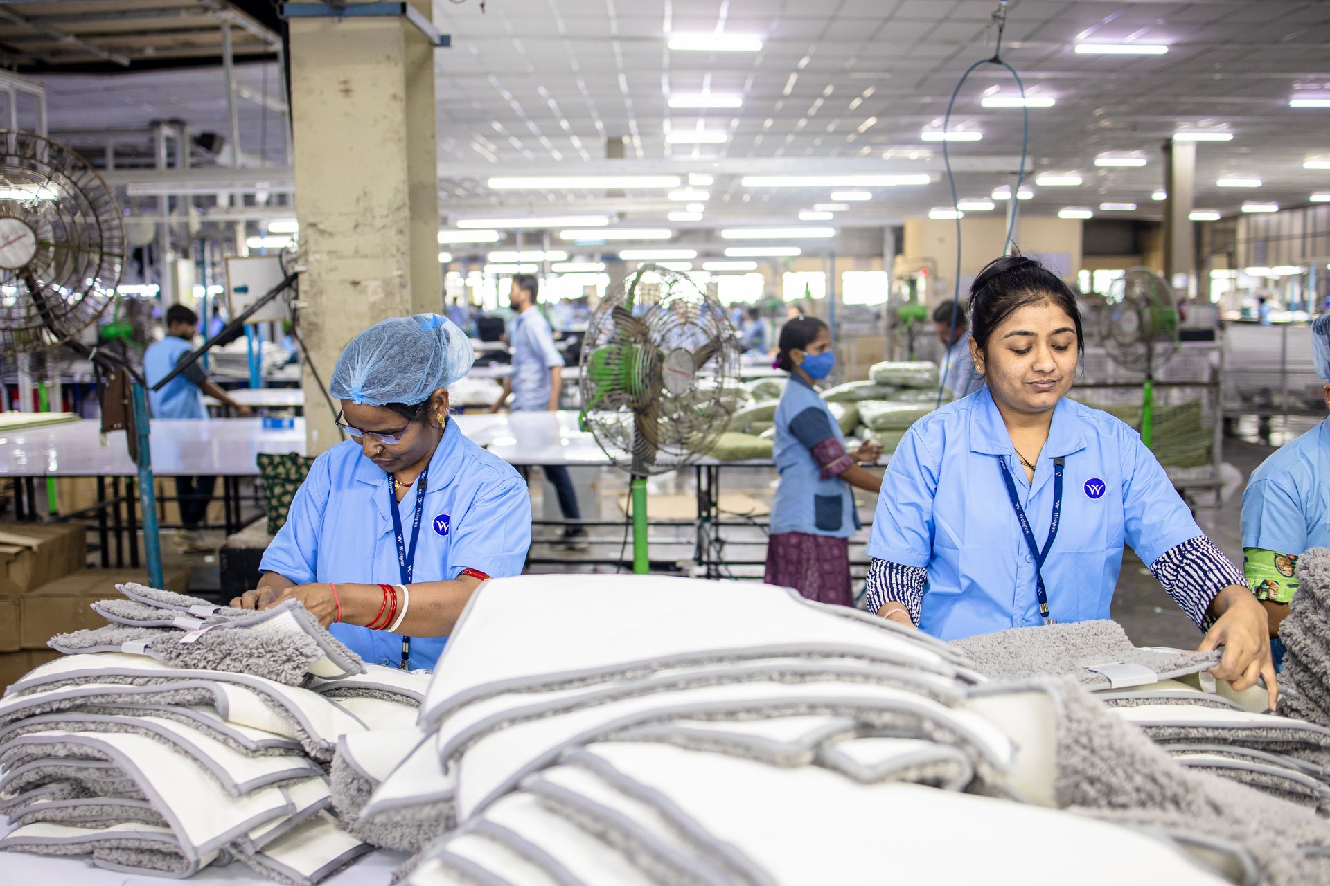 Workers in a textile factory sorting materials, showcasing industrial labor and teamwork.