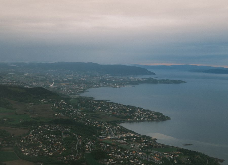 A tranquil aerial view of Norway's southeastern coastline with lush greenery and serene waters.