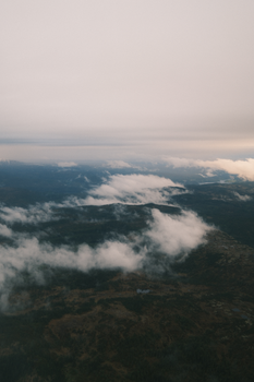 Aerial perspective of clouds and landscapes with a serene dawn sky.