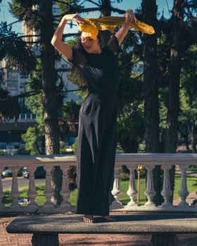 Barefoot woman dancing with scarf in a Buenos Aires park, showcasing grace and freedom.