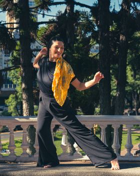 A graceful dancer strikes a pose in a sunny park in Buenos Aires, Argentina.