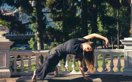 Woman practicing yoga outdoors in a Buenos Aires park on a sunny day.