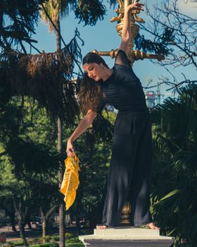 Graceful dancer on a monument in Buenos Aires park, capturing artistry and elegance.