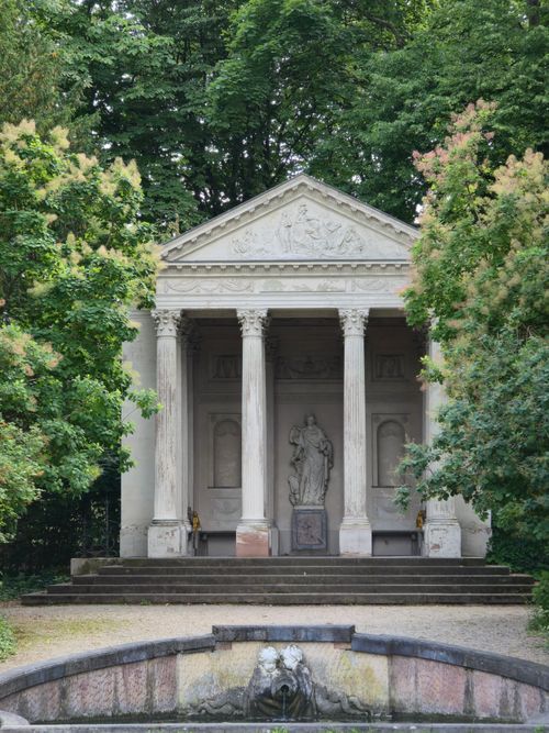 Free Elegant neoclassical pavilion surrounded by lush greenery in a tranquil garden. Stock Photo