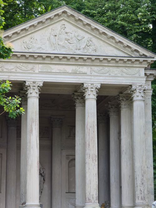 Free Elegant Greek-style temple facade with columns in lush park setting. Stock Photo