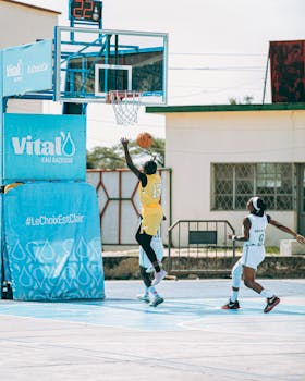 Two players in action during an outdoor basketball game on a vibrant court.