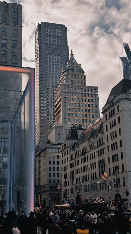 Free Crowded New York City street scene with iconic skyscrapers under a cloudy sky. Stock Photo