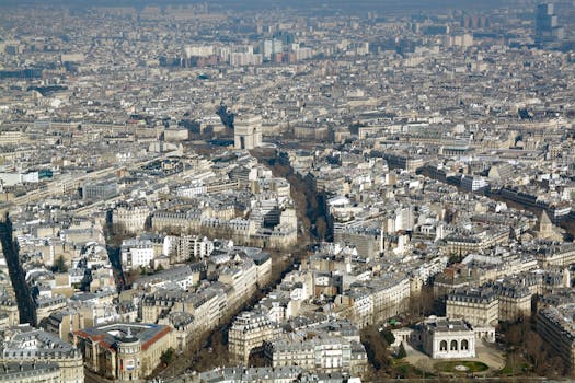 Breathtaking aerial view of Paris with the iconic Arc de Triomphe amidst the dense cityscape.