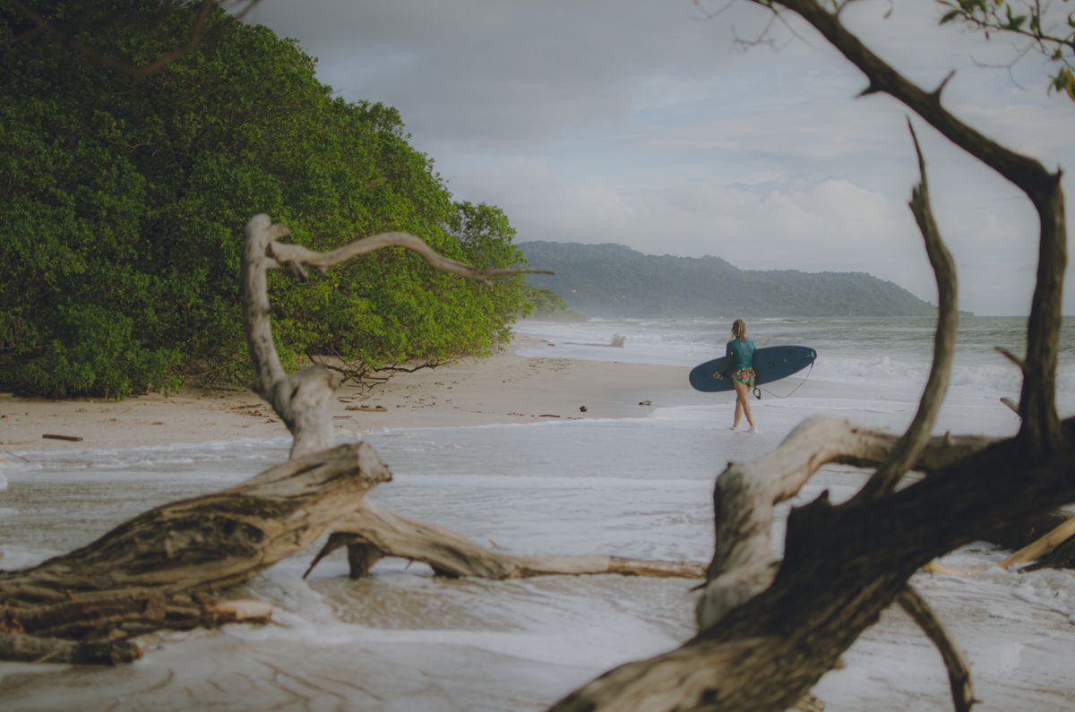 Surfer walking Tamarindo beach