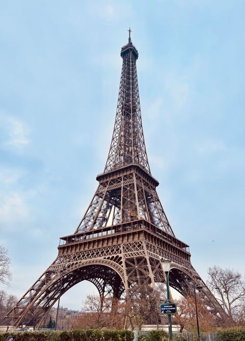 Free Stunning view of the Eiffel Tower in Paris with a bright, clear sky. Iconic landmark shot from a low angle. Stock Photo