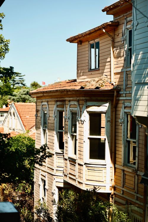Free A vintage wooden house exterior with ornate details under a clear blue sky. Stock Photo