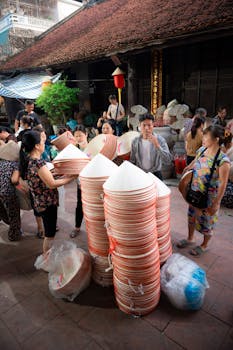 A bustling market in Hà Nội with vendors selling traditional Vietnamese hats.