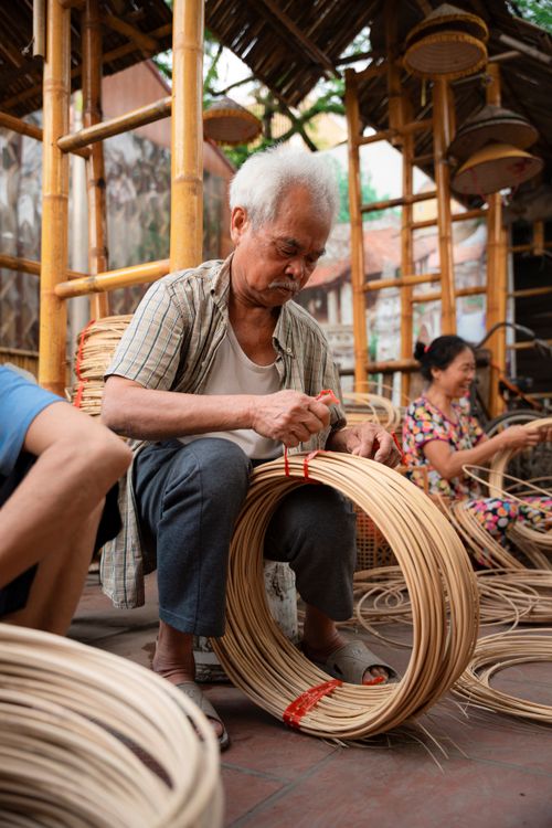 Free Elderly artisan crafting traditional bamboo products in a Hanoi workshop, capturing cultural authenticity. Stock Photo