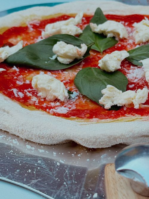 Free Delicious homemade Margherita pizza with fresh basil and mozzarella on a metal tray. Stock Photo