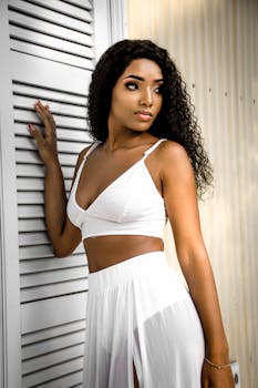 Stylish portrait of a young woman in a white outfit with a confident pose, exuding elegance and fashion.