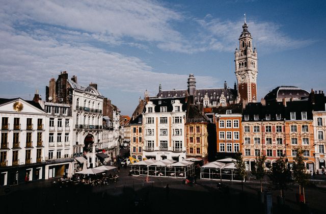 Scenic view of colorful buildings at Lille Grand Place with clear blue sky in daylight. — arriving in Lesquin