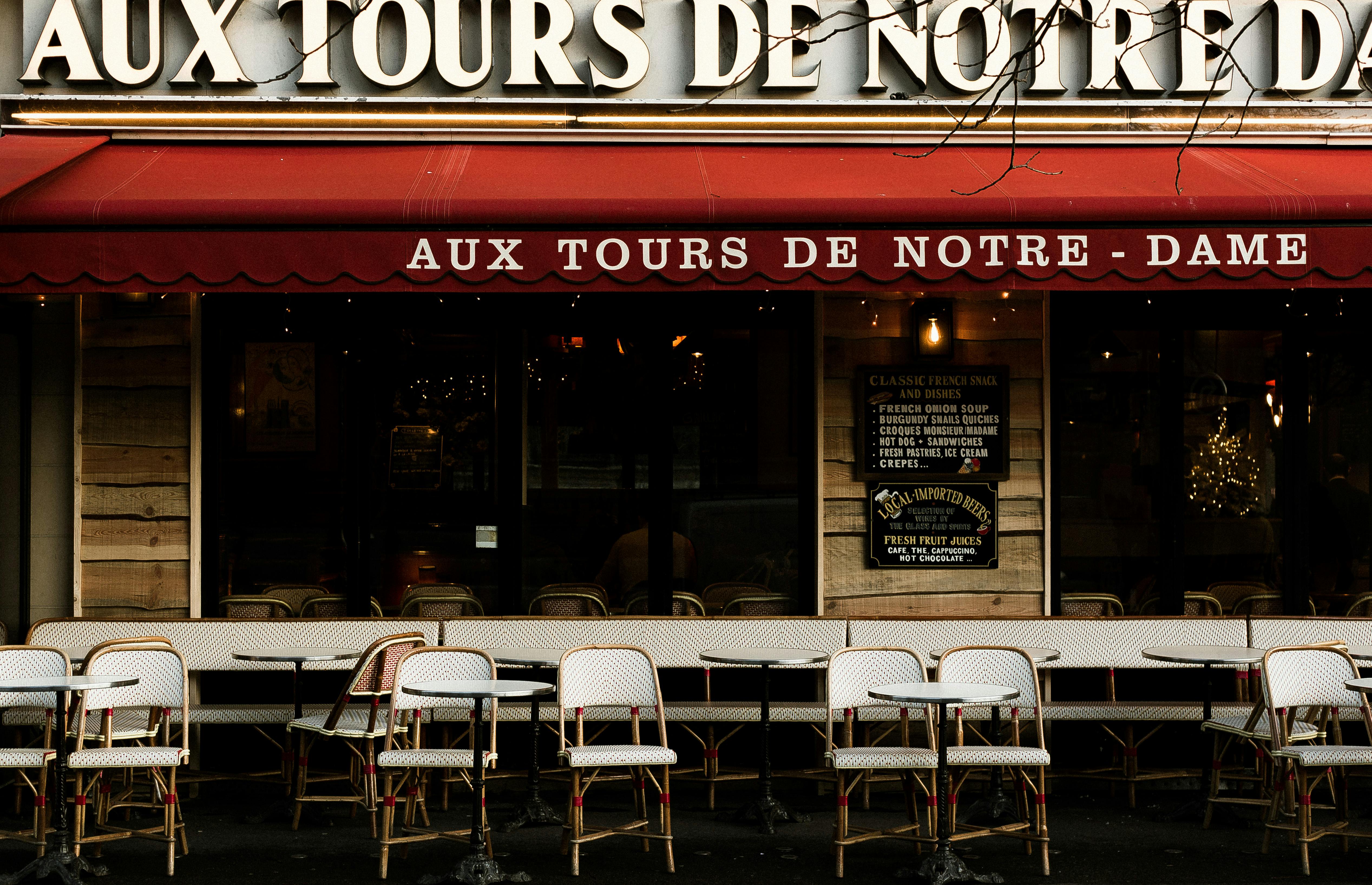 Front view of Aux Tours de Notre Dame cafe in Paris, featuring outdoor seating and iconic French decor.