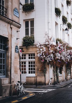 Picturesque Parisian street corner with bicycle and blooming flowers, capturing timeless elegance.