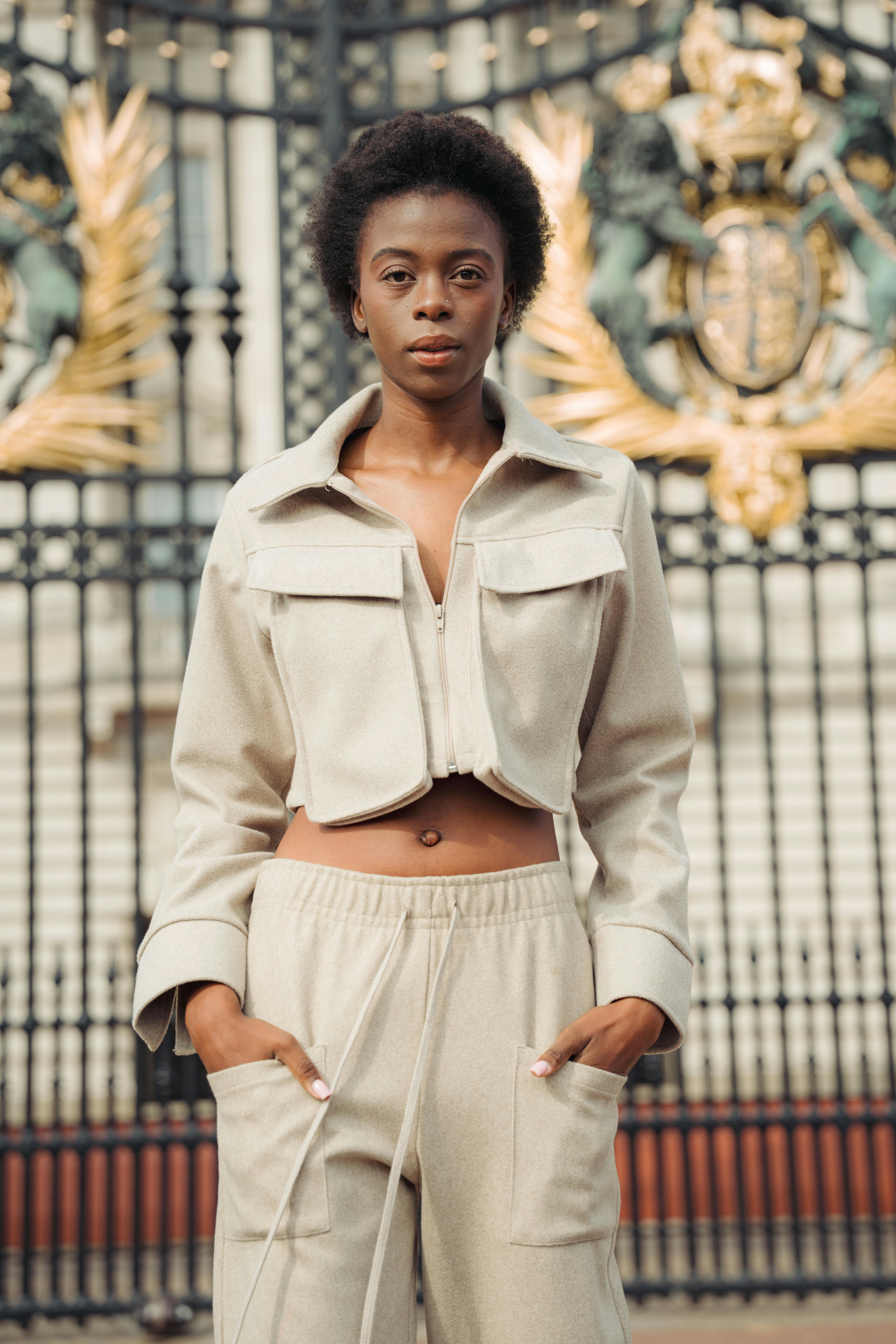 Stylish woman posing confidently at Buckingham Palace in London.