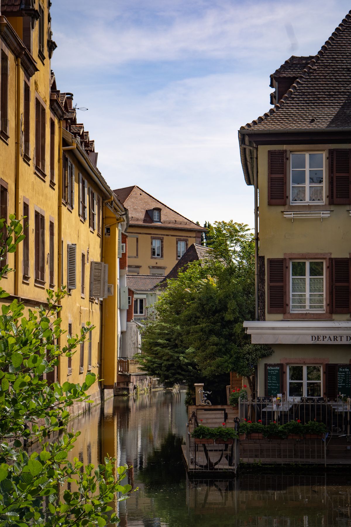 Canalul din Colmar mărginit de case colorate din lemn, în cartierul Little Venice