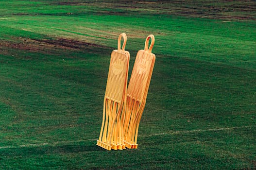 Bright orange soccer training dummies on a vivid green football field.
