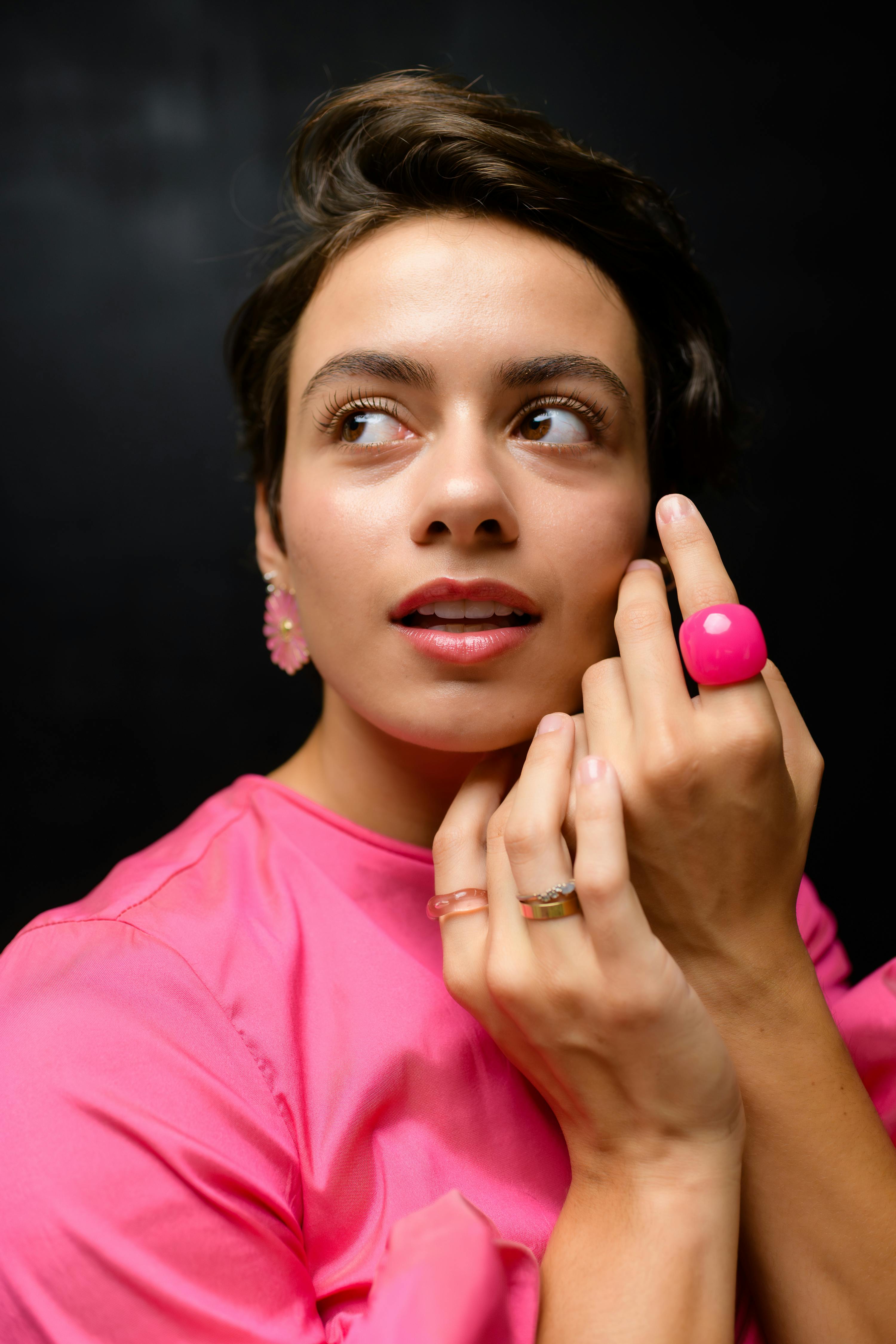 Zadarmo Štýlová žena v ružovom tope s ladiacimi doplnkami, v nápadnej póze v interiéri. Fotka z fotobanky