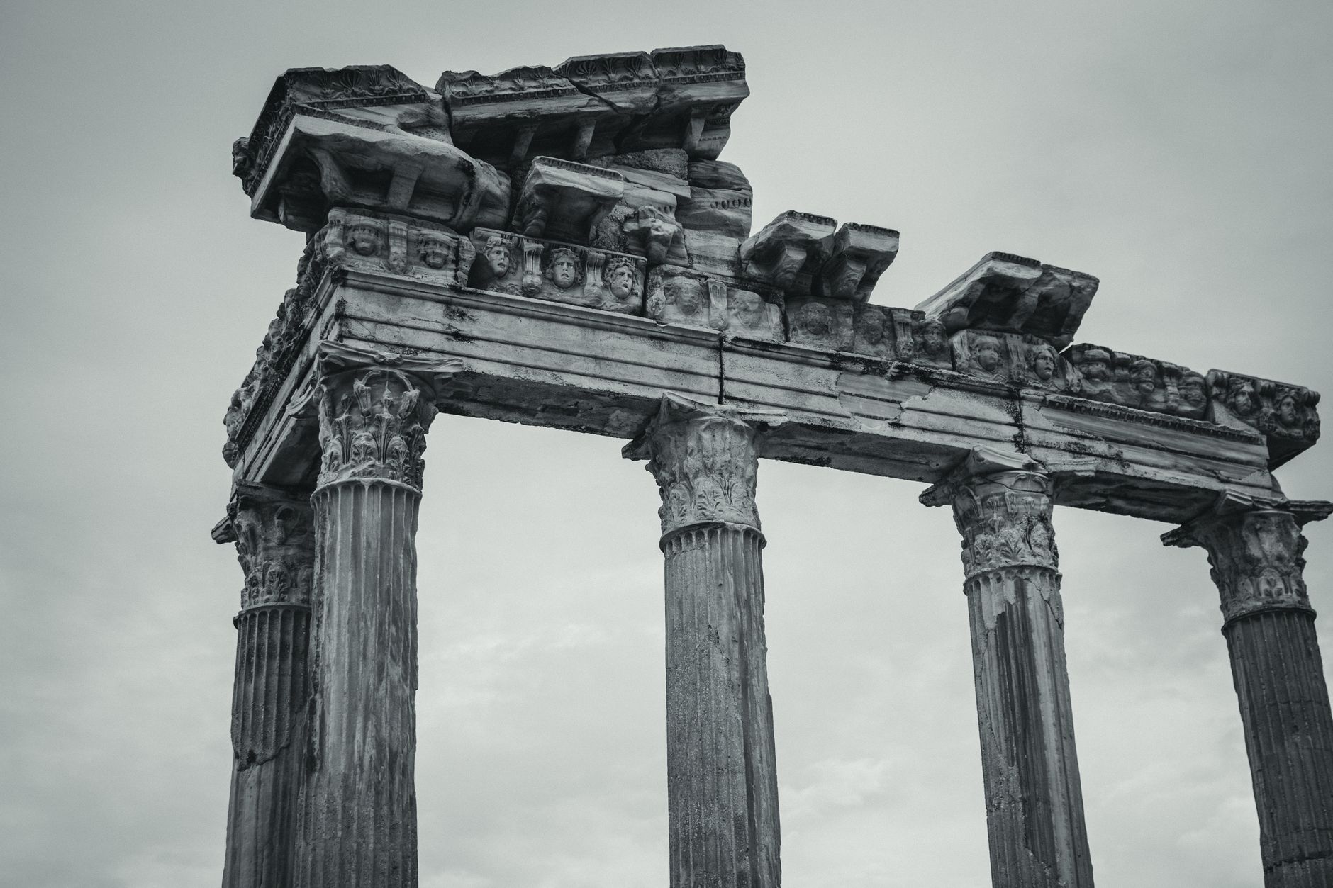 Stunning black and white photograph of ancient Roman temple columns, showcasing detailed architectural carvings.