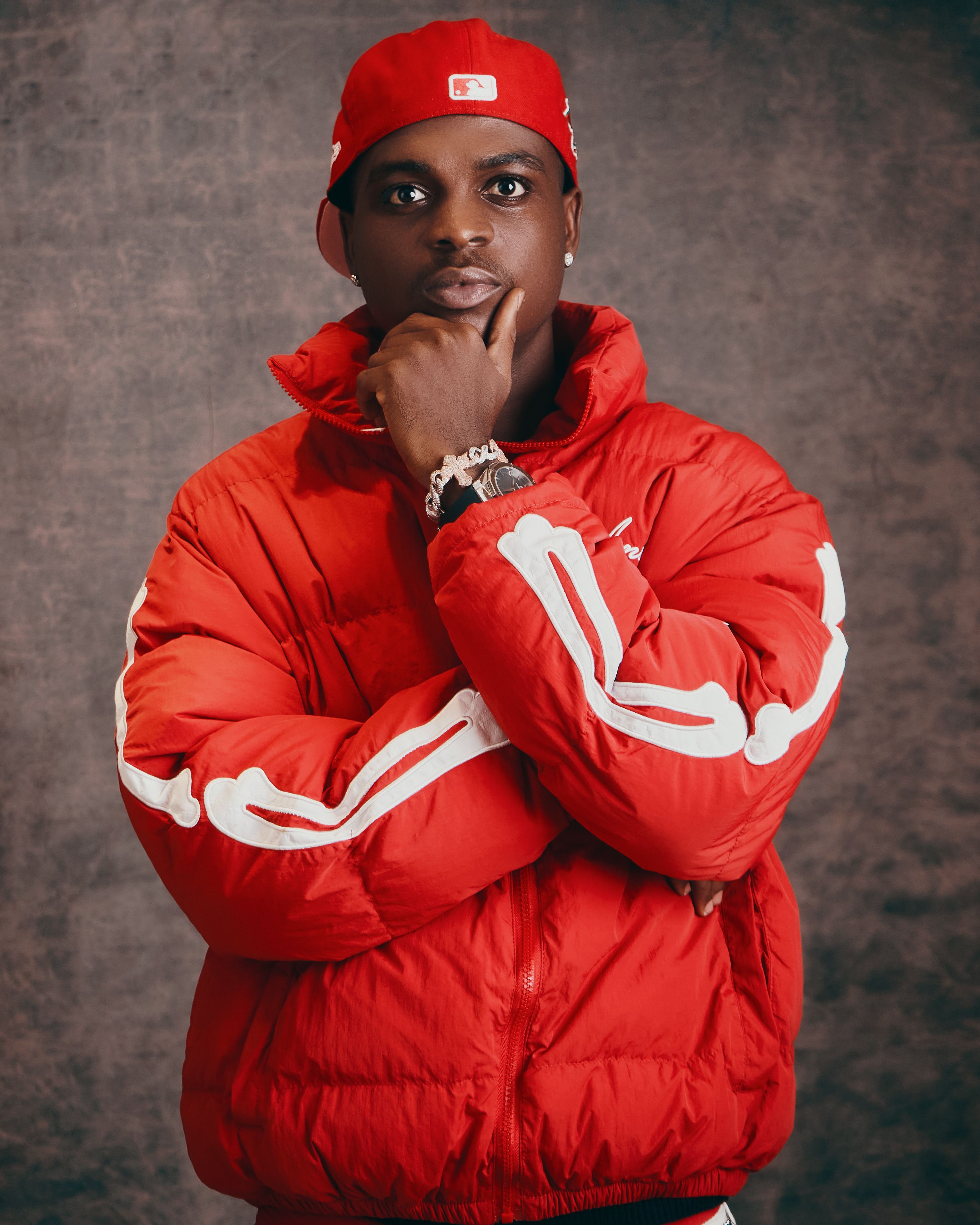 Confident man in a stylish red outfit posing thoughtfully indoors.