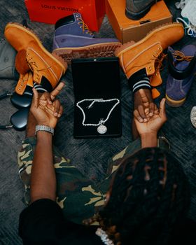 Flat lay of luxury necklaces with branded shoeboxes and boots. Elegant presentation.