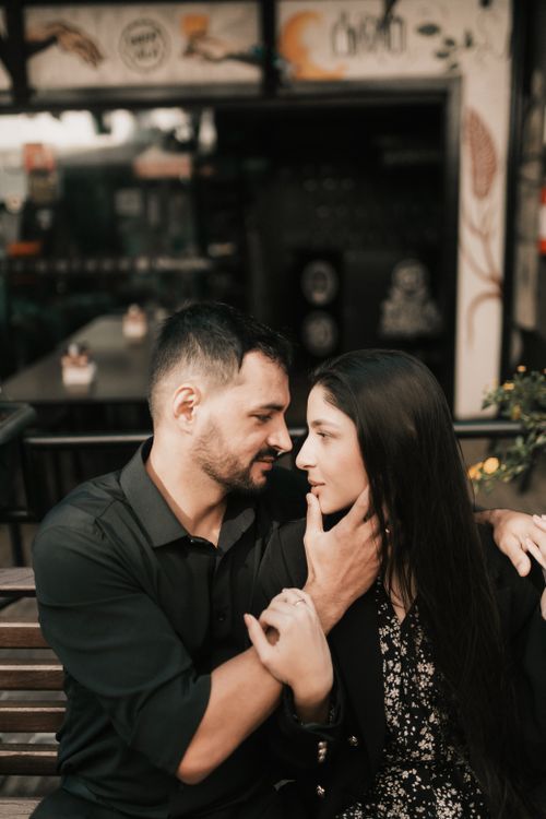Free Couple embracing intimately at an outdoor café, creating a romantic mood. Stock Photo