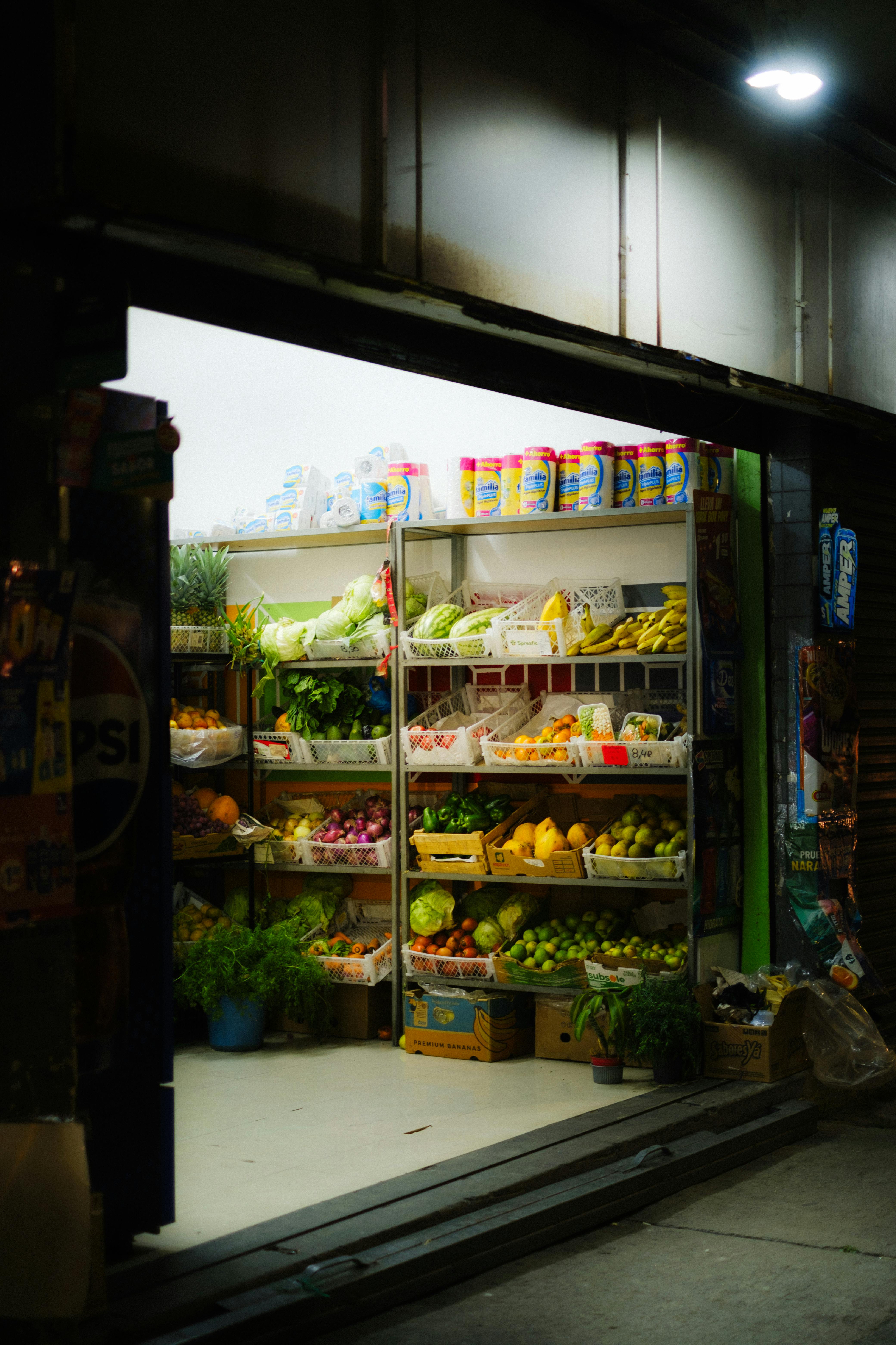 Devanture de petite épicerie avec fruits et légumes.