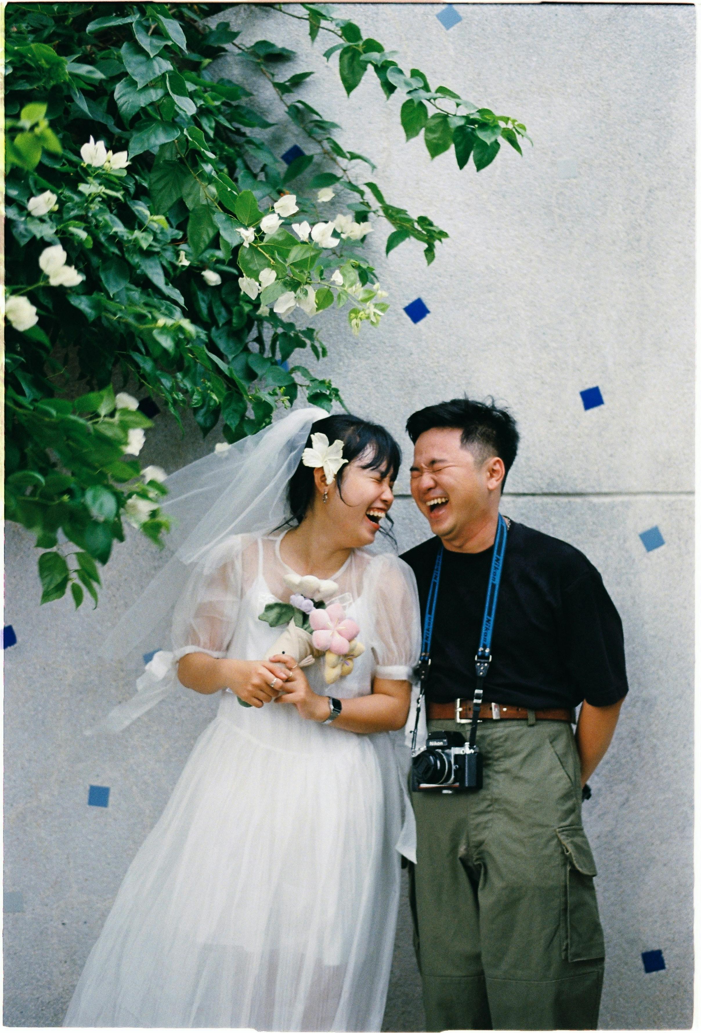A happy couple celebrates their wedding day with laughter and joy outdoors.