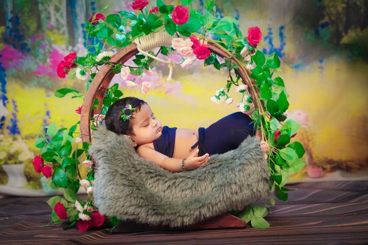 A peaceful baby sleeping in a decorative floral basket, surrounded by colorful flowers.