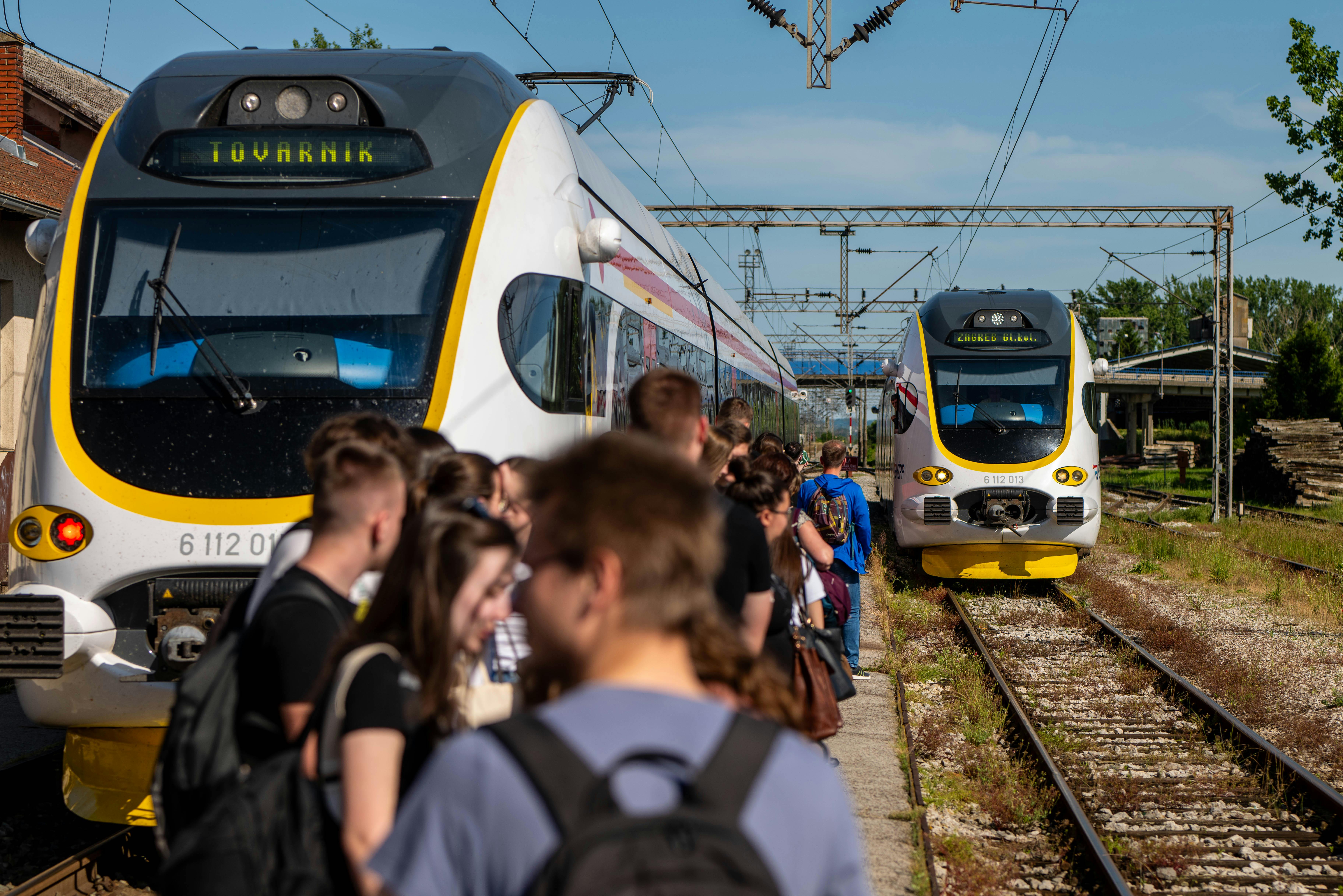 Free Passengers waiting to board trains at Kutina station, capturing an everyday travel scene. Stock Photo