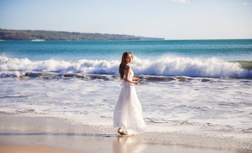 grátis Foto De Foco Raso De Mulher De Vestido Branco Na Praia Foto profissional