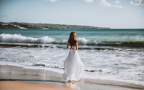 Free Woman Facing The Ocean Stock Photo