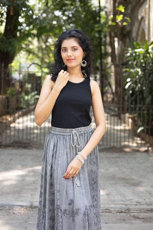 Free Portrait of a young woman in stylish attire, outdoors in a sunny environment. Stock Photo