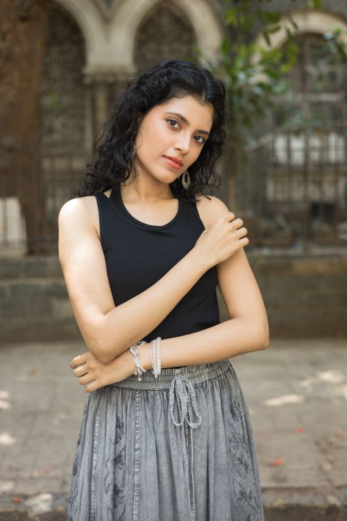 Free Confident woman outdoors in a stylish black top and grey skirt. Stock Photo