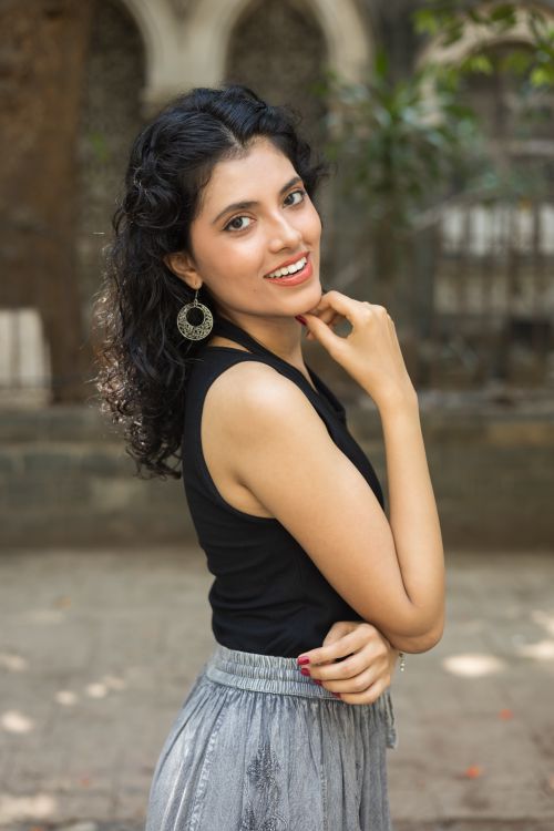 Free Portrait of a smiling woman in stylish clothing posing outdoors on a summer day. Stock Photo