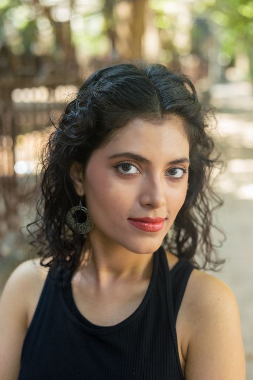Free Beautiful outdoor portrait of a young woman with curly hair and earrings, showcasing confident elegance. Stock Photo