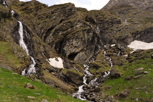 Free Breathtaking view of a vibrant waterfall flowing down a rugged mountain landscape. Stock Photo