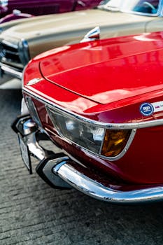 Close-up of a classic red car showcased in Bratislava, highlighting its vintage design and chrome details.