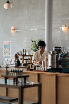 Barista arranging cups in a trendy Yokosuka cafe, showcasing modern interior style.